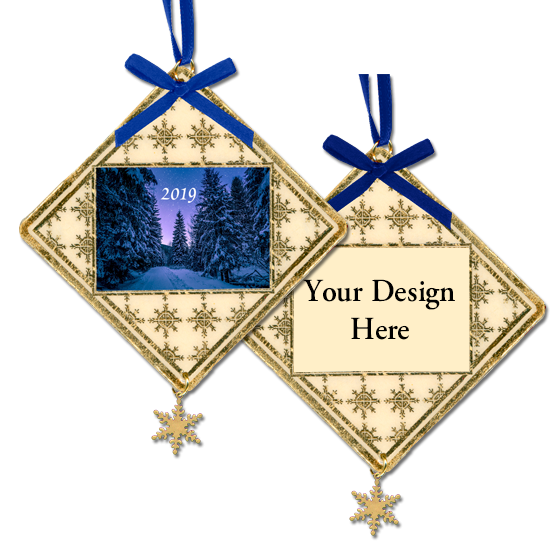 Laminated holiday ornament with gold foil snowflake decoration and image with snow-covered pines with purple sunset next to example with 